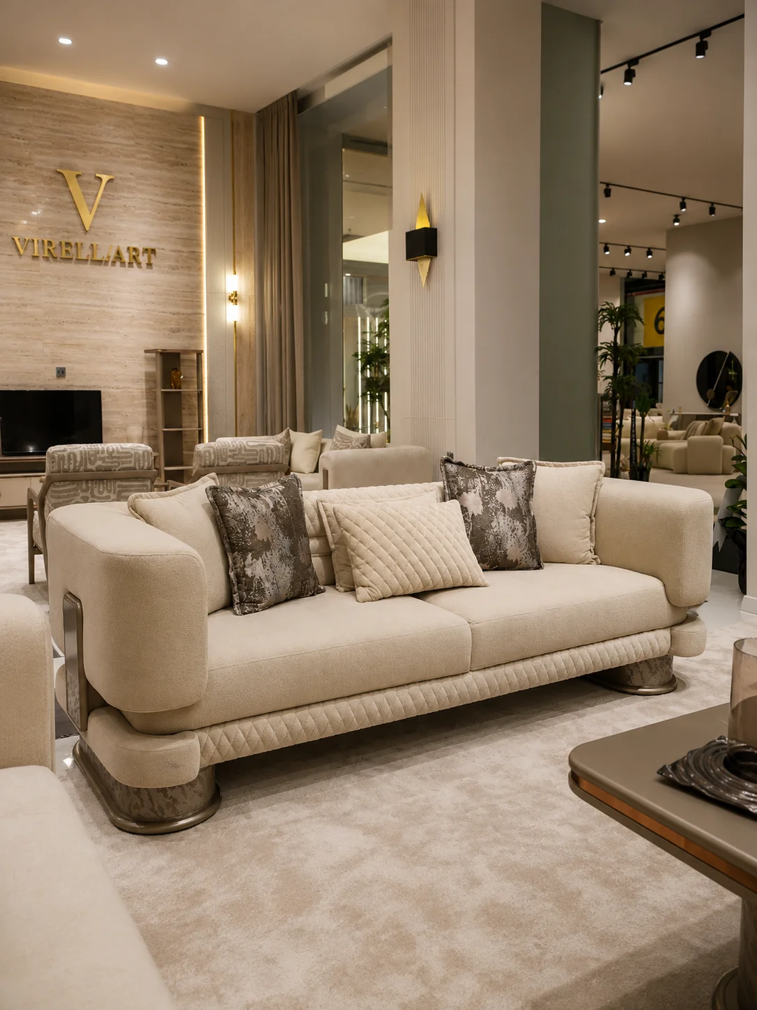 Aspendos ivory three-seat sofa front view with curved arms, quilted lower trim and patterned cushions