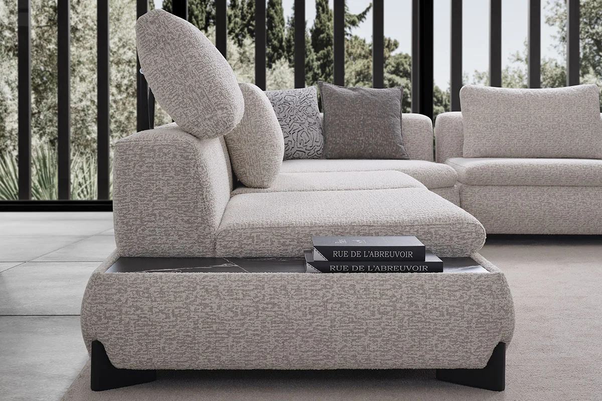 Aura swivel armchair with graphic patterned upholstery beside the modular corner sofa and center table