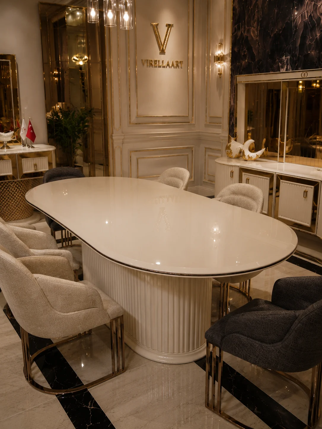 Deluxe oval ivory dining table with a fluted pedestal base, cream and charcoal chairs and matching console in the background